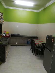 瓜拉丁加奴HOMESTAY DAMAI YUSMILA的厨房配有桌子和绿色的墙壁