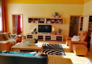 玛丽亚温泉Apartment Villa Frank的客厅配有橙色家具和平面电视。