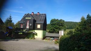 库罗阿尔滕堡Gästehaus Meierbaude的绿色和黑色的房子,上面有太阳能电池板