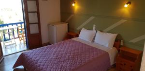 阿洛尼索斯古镇Fantasia House的一间卧室配有一张带紫色棉被的床