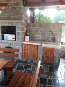波尔托罗Rooms & Apartments Giulia的厨房配有石制壁炉、木桌和椅子