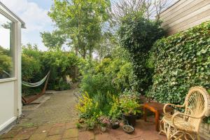 鹿特丹Residentie Blijdorp的一个带椅子和植物的花园以及围栏
