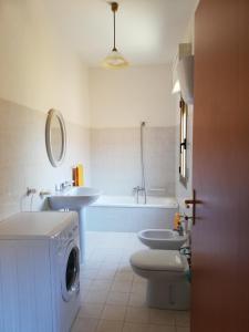 弗卢米尼马焦雷Casa vacanza的浴室配有卫生间、盥洗盆和洗衣机。