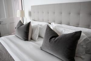 斯泰伦博斯Heritage House的一张带四个枕头的白色床