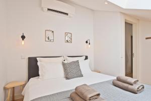 里斯本Vila Olarias的卧室配有带毛巾的大型白色床