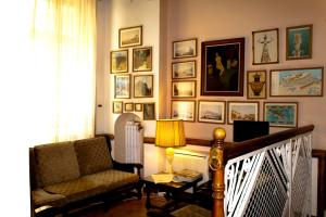 雅典卫城酒店的客厅配有椅子,墙上挂有图片