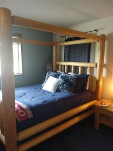 奥克港Wildwood Farm Bed & Breakfast的一间卧室配有一张带蓝色床单的木制双层床