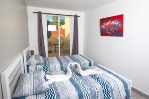 圣多明各La Aldea的一间卧室配有两张带蓝白色床单的床