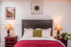 比斯比Jonquil Motel的一间卧室配有一张带红色床单的大床和两盏灯。