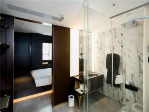 上海上海国际旅游度假区CitiGO欢阁酒店的一间带玻璃淋浴间的浴室和一间卧室