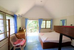 蔻立海神别墅旅馆的卧室配有床、椅子和窗户。