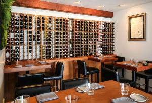 尤克卢利特Pluvio restaurant and rooms的餐厅设有桌子和葡萄酒瓶壁