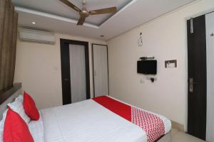 阿拉哈巴德Hotel Mandiram的一间卧室配有一张带红色枕头的床和吊扇