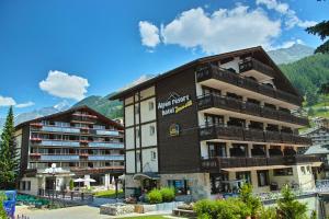 采尔马特Alpen Resort & Spa的一座带阳台的大建筑