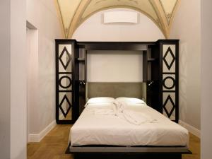 佛罗伦萨Vivaldi luxury suites的一间卧室配有一张带黑白床头板的床