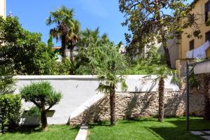 佛罗伦萨Vivaldi luxury suites的院子内种有棕榈树的白色围栏