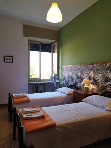 托斯科拉诺-马德尔诺Ostello delle cartiere的酒店客房,设有两张床和一张沙发
