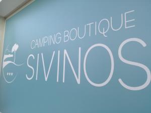 马内尔巴Sivinos Camping Boutique的蓝墙上任何精品滑雪的标志