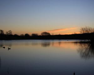 巴斯樱桃园农场酒店的日落时分在水中有两个鸭子的湖泊