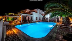 圣安娜纳克索斯安妮塔乡村酒店的一座大型游泳池,在晚上在房子前面