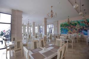 谢赫维蒂利Black Sea Riviera Hotel的用餐室配有桌椅和壁画