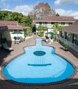 奥克兰杜克米德威酒店的一座位于庭院的大型游泳池,庭院内有一座建筑