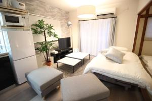 大阪CASA GRApP Shotenshita的一间卧室配有一张床、一台电视和一张桌子
