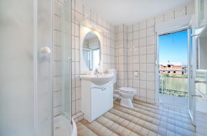沃迪切Apartmani Patača的白色的浴室设有水槽和卫生间。
