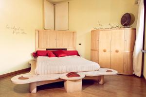 米兰eco Hotel Milano & BioRiso Restaurant的一间卧室配有一张带红色枕头的木床。