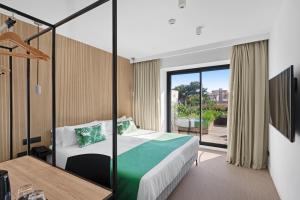 帕尔马海滩Hotel Paradiso Garden的酒店客房设有一张床和一个阳台。
