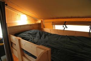 WarmsenFerienhof BrinkOrt的一个小房子里的一个空的双层床