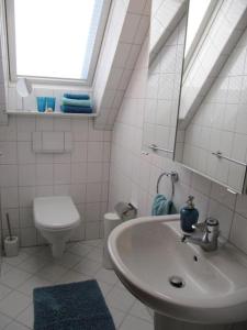 巴特法灵博斯特尔Weissewolke的白色的浴室设有水槽和卫生间。