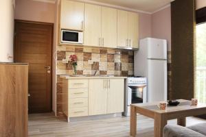 代诺维奇Mimoza Apartments的厨房配有白色橱柜和白色冰箱。