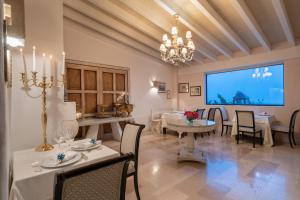 马蒂纳塔罗坎达卡卢博酒店的一间设有白色桌椅和大屏幕的用餐室