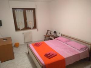 马泰拉Home Sweet Home的一间卧室配有一张带粉色和橙色床单的床