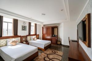 波来古市Duc Long Gia Lai Hotels & Apartment的酒店客房设有两张床和一台平面电视。