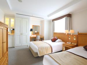 佐仓市由香里威仕顿酒店的酒店客房设有两张床和窗户。
