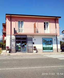 拉默齐亚泰尔默Santa e Maria Affittacamere的街道边的粉红色和白色建筑