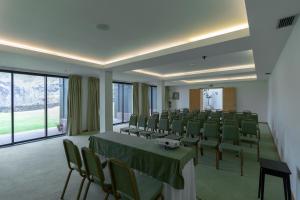 卡罗拉卡罗拉度假酒店的一间会议室,配有绿色的椅子和桌子以及窗户