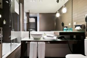 巴塞罗那Hotel Barcelona Condal Mar Affiliated by Meliá的一间带水槽、浴缸和淋浴的浴室