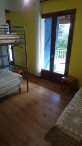 科洛米耶友好旅舍的一间卧室配有一张双层床,并设有一个通往阳台的门。