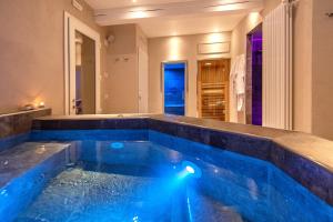 迪科马诺Borgo di Villa Cellaia Resort & SPA的蓝色房子中的游泳池