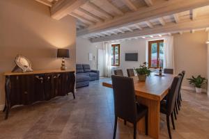 迪科马诺Borgo di Villa Cellaia Resort & SPA的用餐室和带木桌的客厅