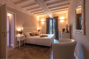 迪科马诺Borgo di Villa Cellaia Resort & SPA的卧室配有白色的床和椅子