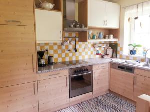 尼德恩西尔尼德恩西尔度假屋的厨房配有木制橱柜和烤箱。