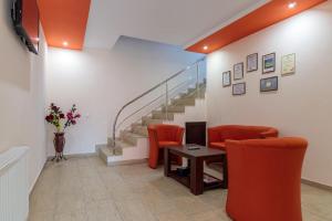 拉姆尼库沃尔恰Pensiunea Arthur的一间设有橙色椅子、桌子和楼梯的等候室