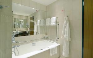 伦敦加那利滨江广场酒店的带浴缸、水槽和镜子的浴室