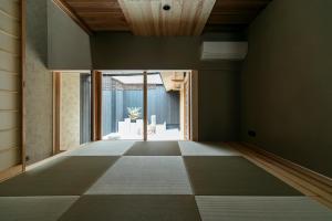 京都MACHIYADO 京都南禅寺道的一间空房间,设有大窗户和瓷砖地板