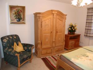 EngedeyHaus Alpenglühn的一间卧室配有大型木制橱柜和椅子