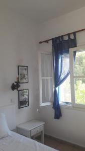 里瓦的亚帕夫洛斯公寓的一间卧室配有床和蓝色窗帘的窗户